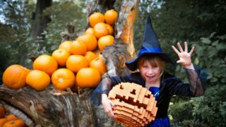 girl in witches hat with lego pumpkin halloween half term october
