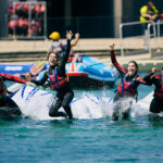 people jumping off the obstacle course into the water