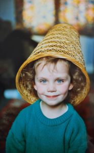 Alex Humphreys as a kid, with a wicker basket on her head