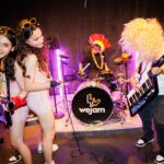 A teen band playing instruments and singing in Camden