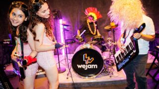 A teen band playing instruments and singing in Camden