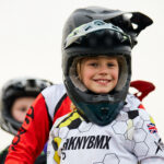 very happy child in a BMX outfit and helmet at Lee Valley Velopark