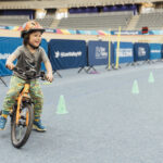 primary school age boy riding a bike around cones