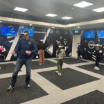 a man and lots of kids all playing a multiplayer VR game, wearing VR headsets at VRXtra Kingston