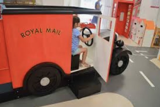 A young girl playing in a kids delivery van in The Postal Museum