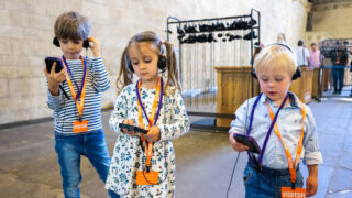 3 children wearing headphones on the Westminster audio tour