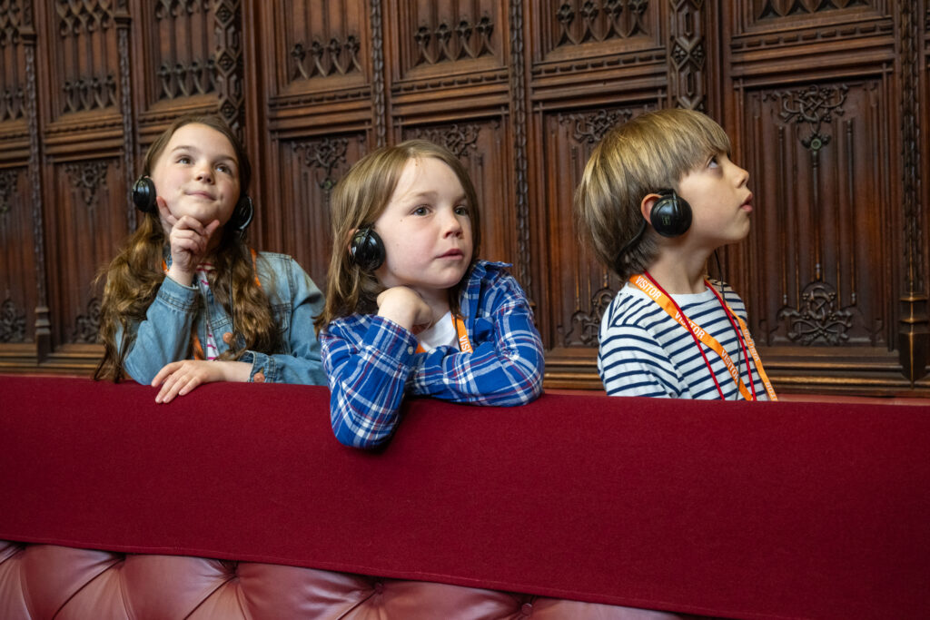 3 children listening to audio tour inside westminster