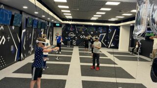 Kids playing on mats wearing VR headsets at VRXtra