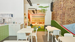 Image of white chairs and tables in clean cafe with play area.
