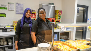 two people serving food at the West Youth zone cafe