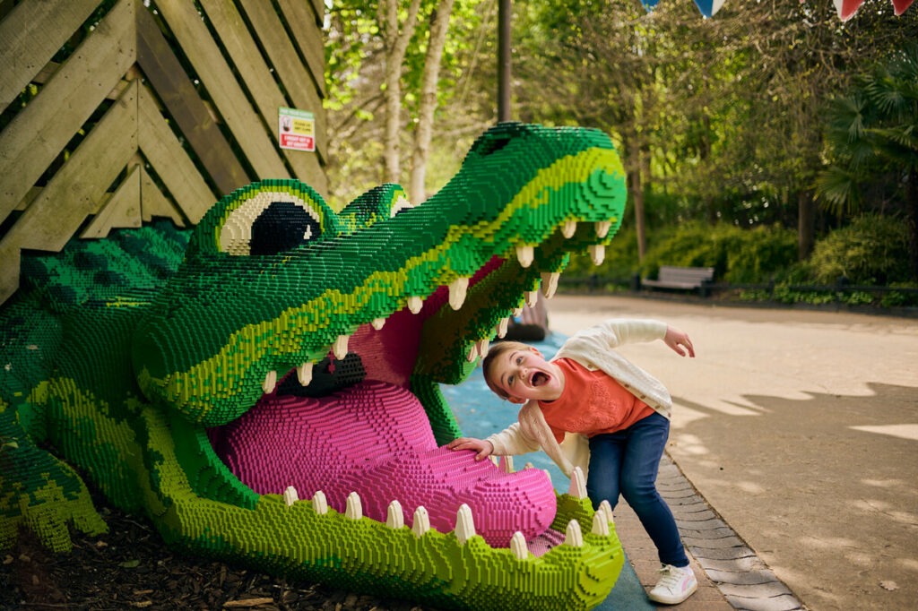Boy putting his head in a lego crocodile